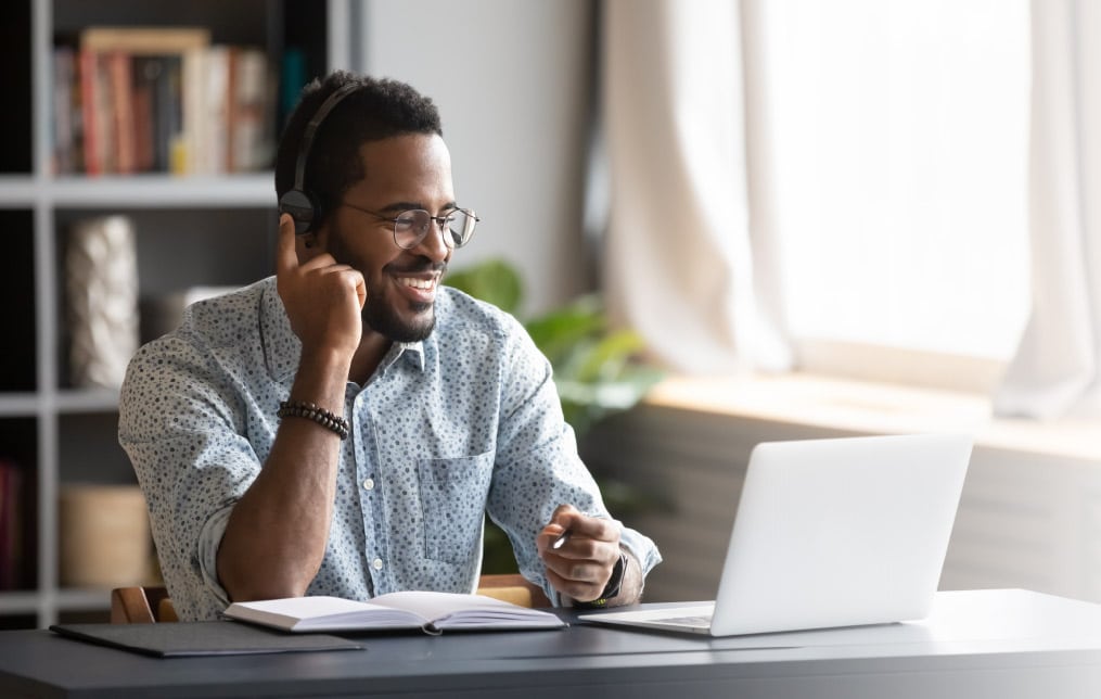 Man with headset on laptop